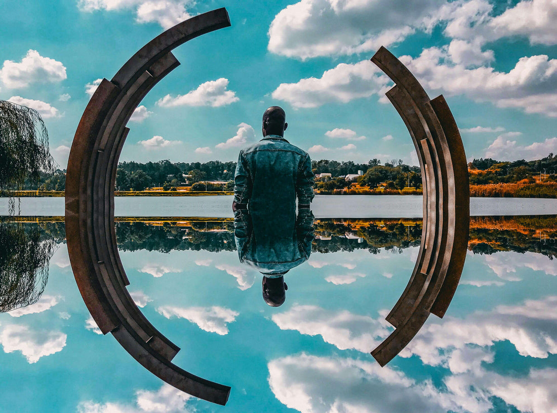 Man Sitting Alone In Front of A Reflective Pool