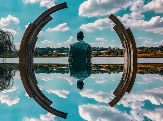 Man Sitting Alone In Front of A Reflective Pool